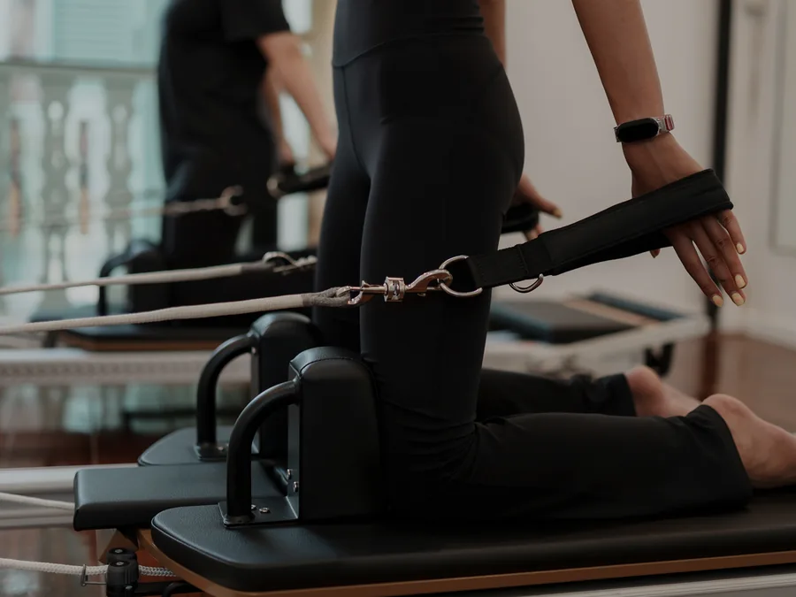 Alumna practicando pilates sobre la máquina reformer