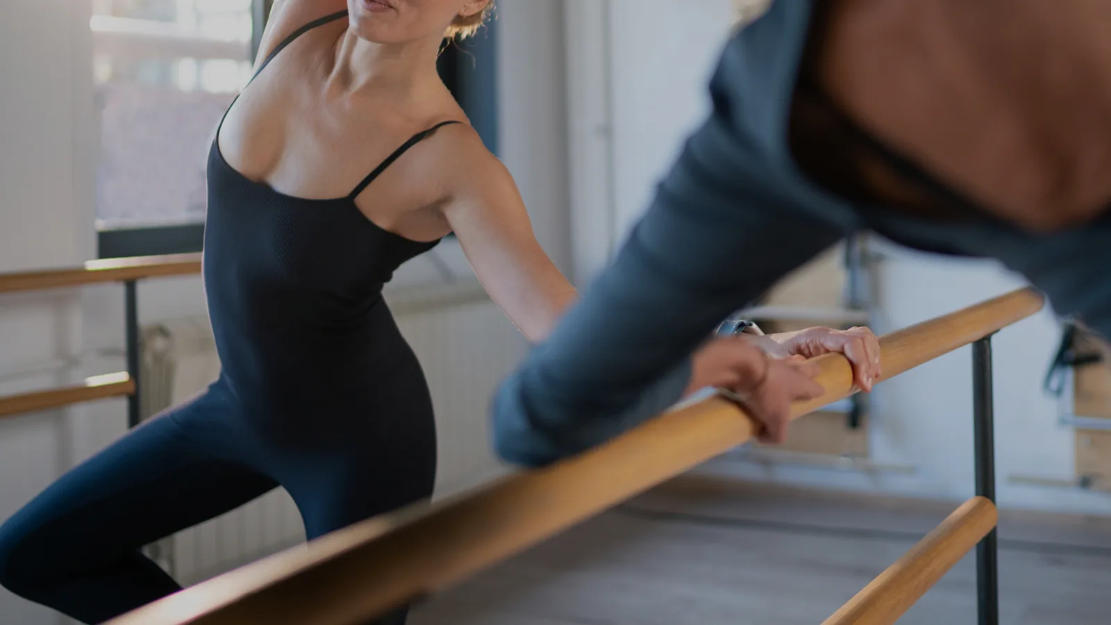 Alumna estirando en el suelo durante una clase